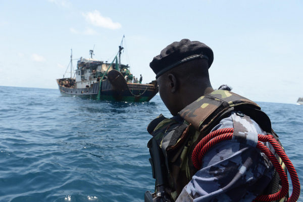 A member of the Ghanaian maritime police looks at a suspected illicit fishing vessel prior to boarding. [Photo: U.S. Naval Forces Europe-Africa]