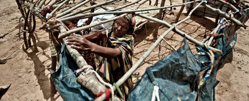 A displaced person builds a shelter at the Mentao Nord camp in Burkina Faso
