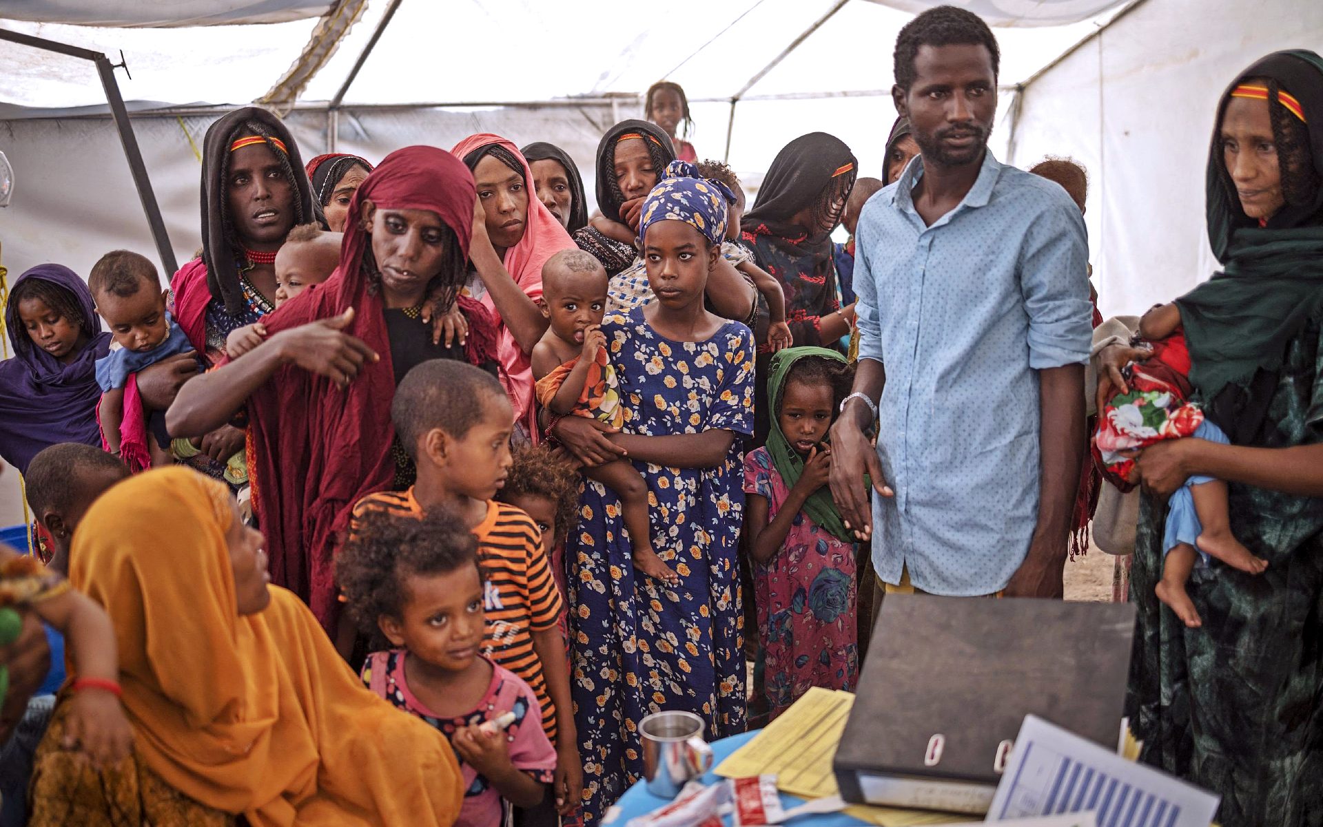 Women and children from the internally displaced persons camp of Guyah, Ethiopia wait to have their children screened by health personnel. (Photo: Michele Spatari/AFP)