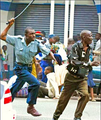 A Zimbabwe police officer chasing a protester in 2005.