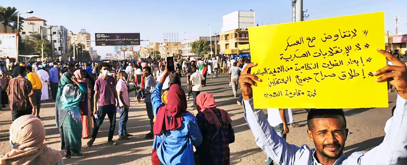 A Sudanese protester holding a sign demanding the military separate from the political process