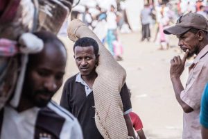 Refugees from Sudan carrying their belongings into Metema, Ethiopia