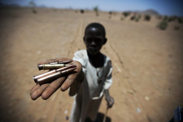 A child holds up bullets collected from the ground in Rounyn, a village in North Darfur.