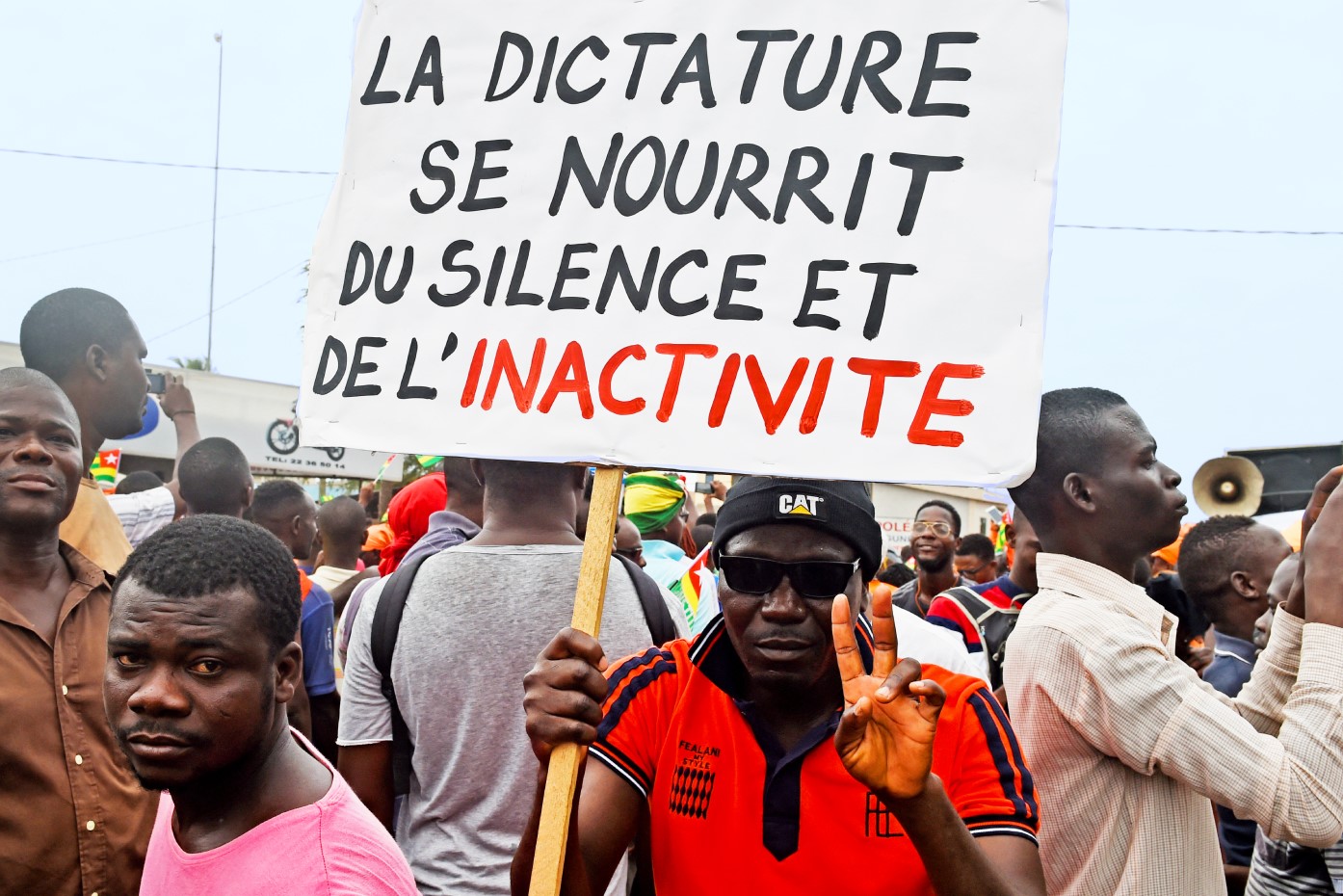 Protesters carry a placard reading “dictatorship feeds on silence and inactivity”