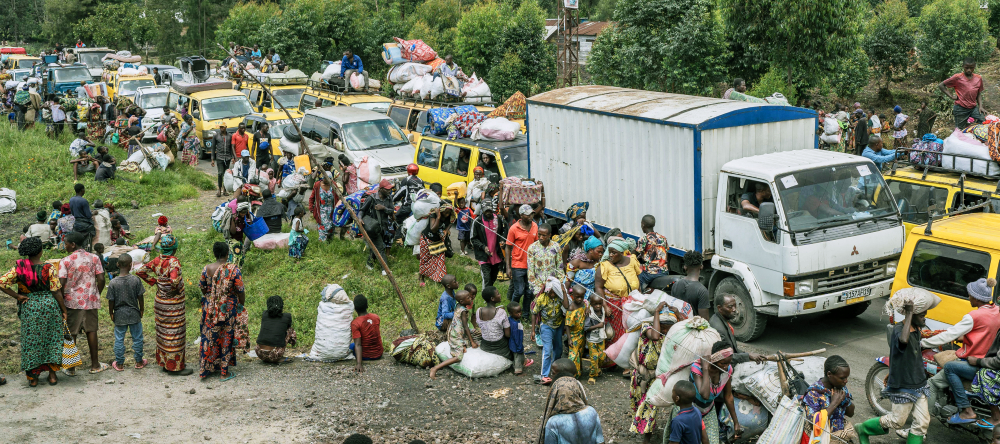 Congolese gather along a busy road while they flee clashes between M23 rebels and government forces in the Masisi territory.