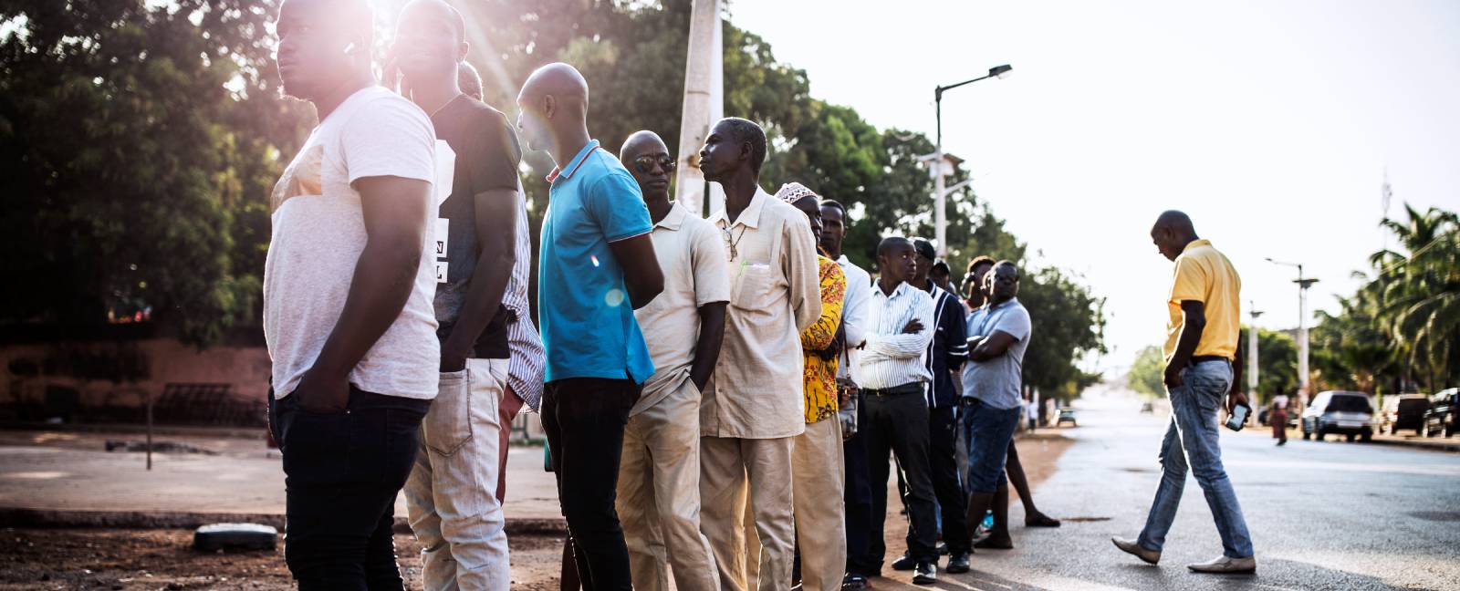 People wait outside a polling station in Bissau early on November 24, 2019, as part of the presidential election in Guinea-Bissau.