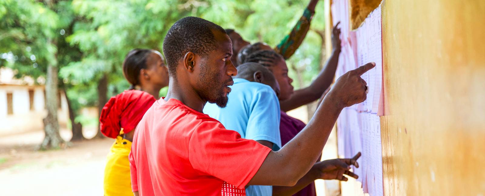 Citizens look for their names on voters lists before casting their vote during a Tanzanian local election. (Photo: AFP)