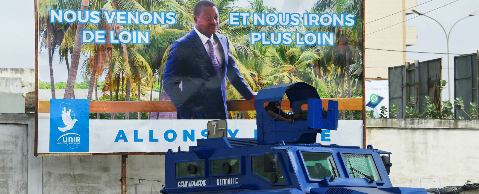 A police Armored Personnel Carrier is parked in front of a campaign billboard for President Faure Gnassingbe, candidate of the ruling Union for the Republic (UNIR) party. (Photo: AFP/Pius Utomi Ekpei)