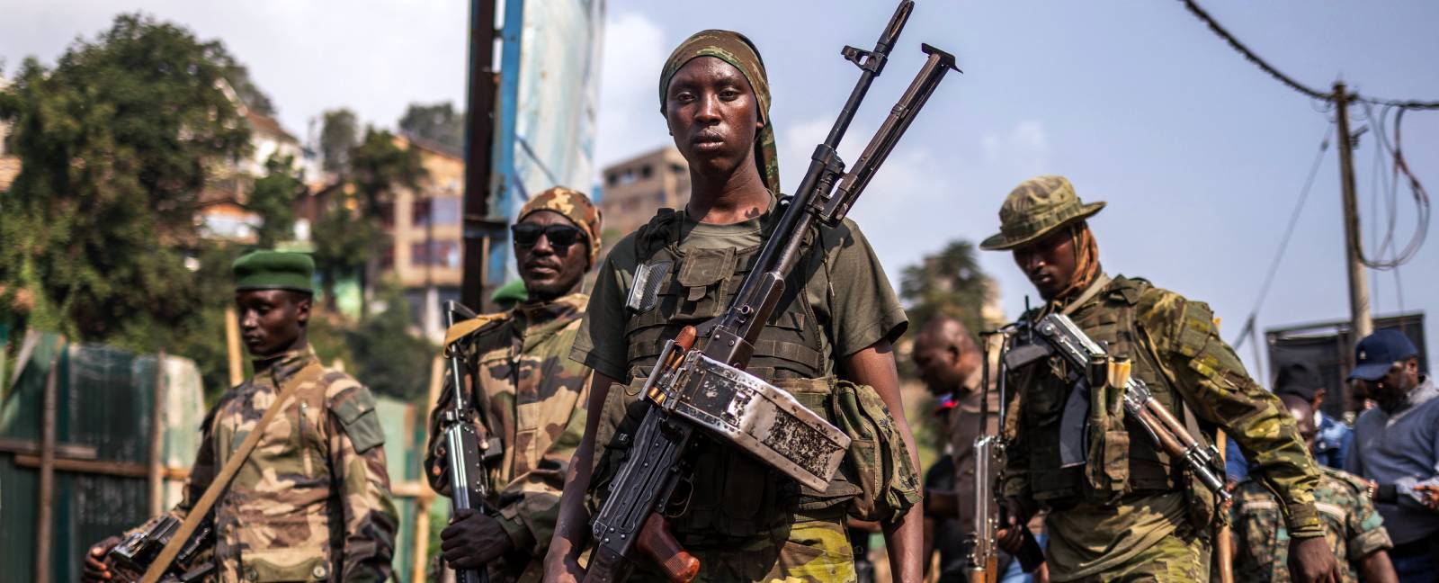 Armed fighters of the M23 Movement walk down a street in Bukavu.