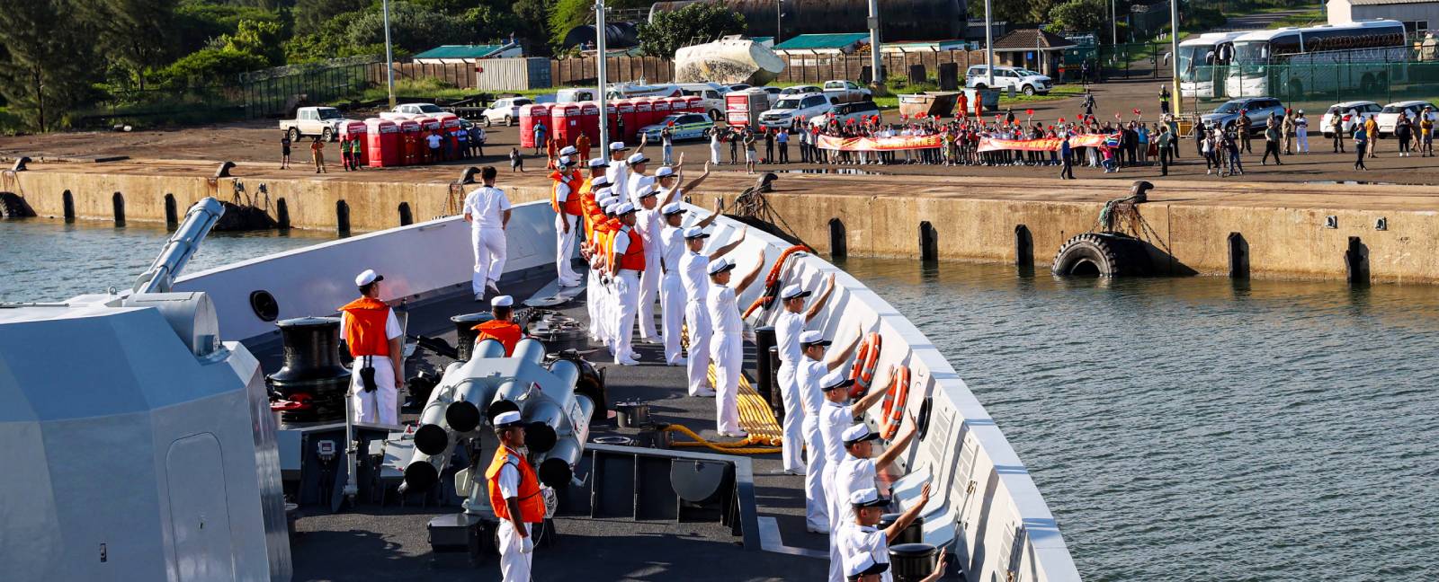 Sailors aboard a Chinese military vessel wave to local residents of Richards Bay, South Africa.