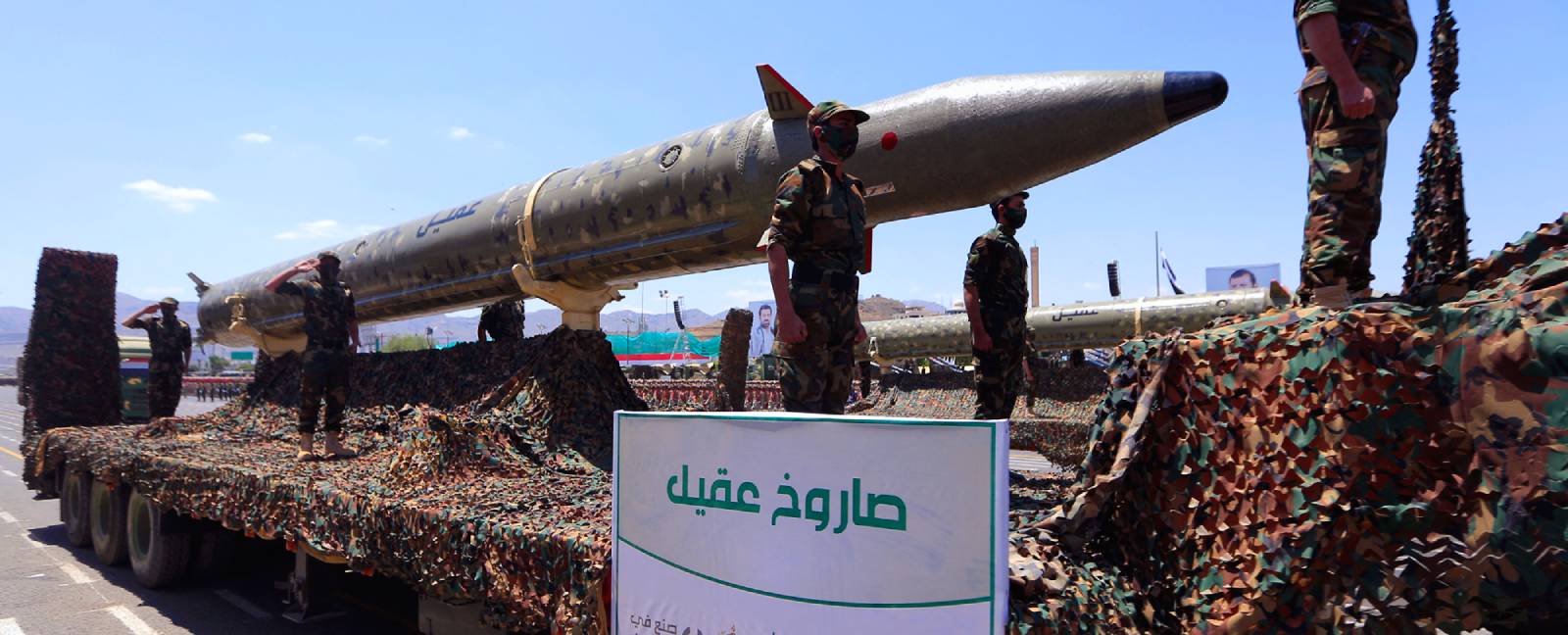 Houthi missile A large missile sits on a carrier with Houthi soldiers standing around it