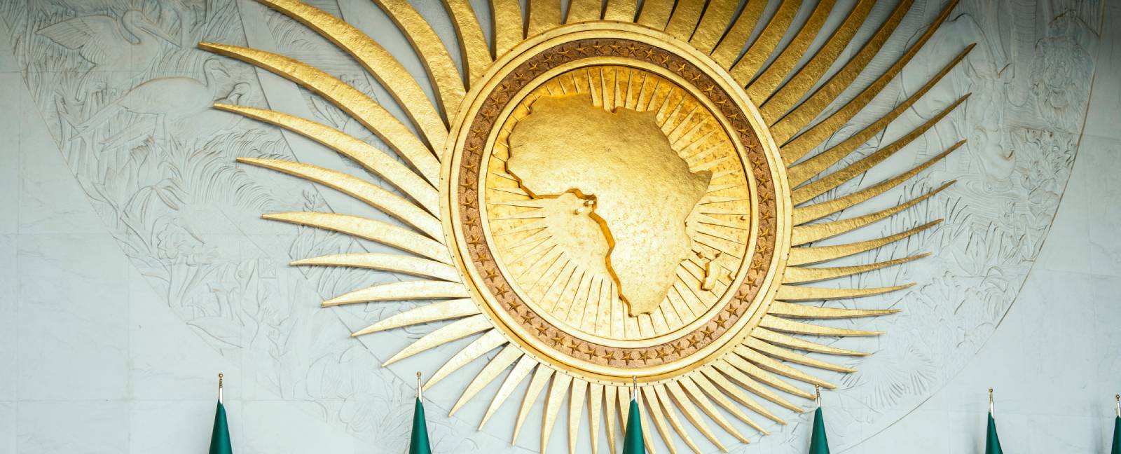 AU headquarters logo A golden logo of the African Union on a wall.