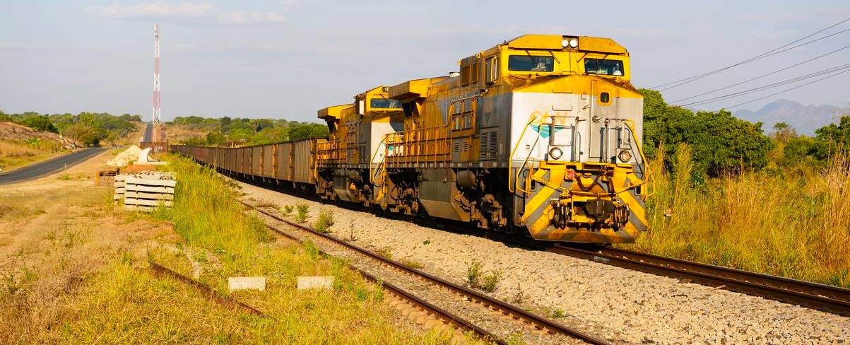 A yellow freight train at a stop point.